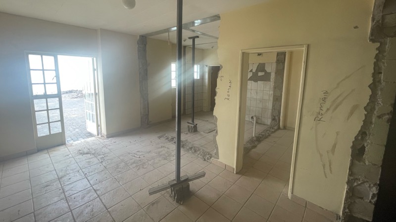 The old entrance area with partitions removed and a glass door still in place.