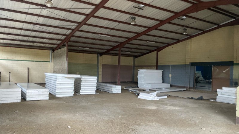 Stacked insulated cold-room panels waiting to be installed inside the warehouse.