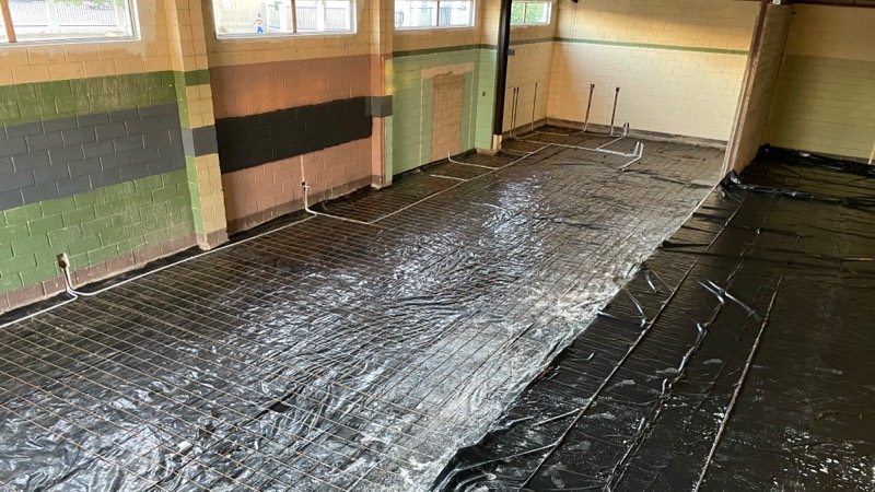 Reinforcement mesh and damp-proof sheeting laid across the floor before the concrete pour.