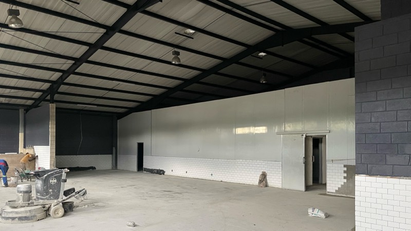 The main retail space with dark walls and the cold room in place.